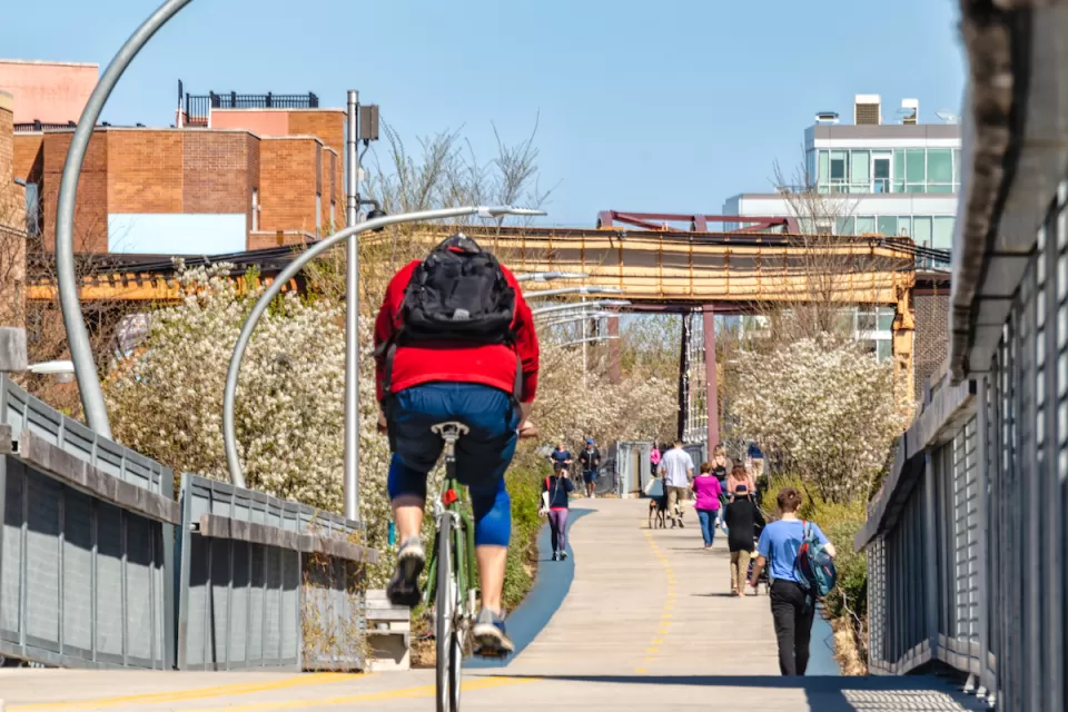 People on bikes and walking on 606 Bloomingdale Bike Trail on sunny day in Chicago, Illinois.